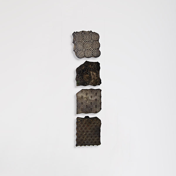 Four hand-carved wooden printing blocks displayed as wall décor