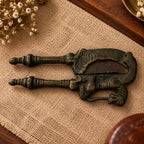 Antique nutcracker with mythical horse-and-rider figure cast at the hinge, front view on a textured surface
