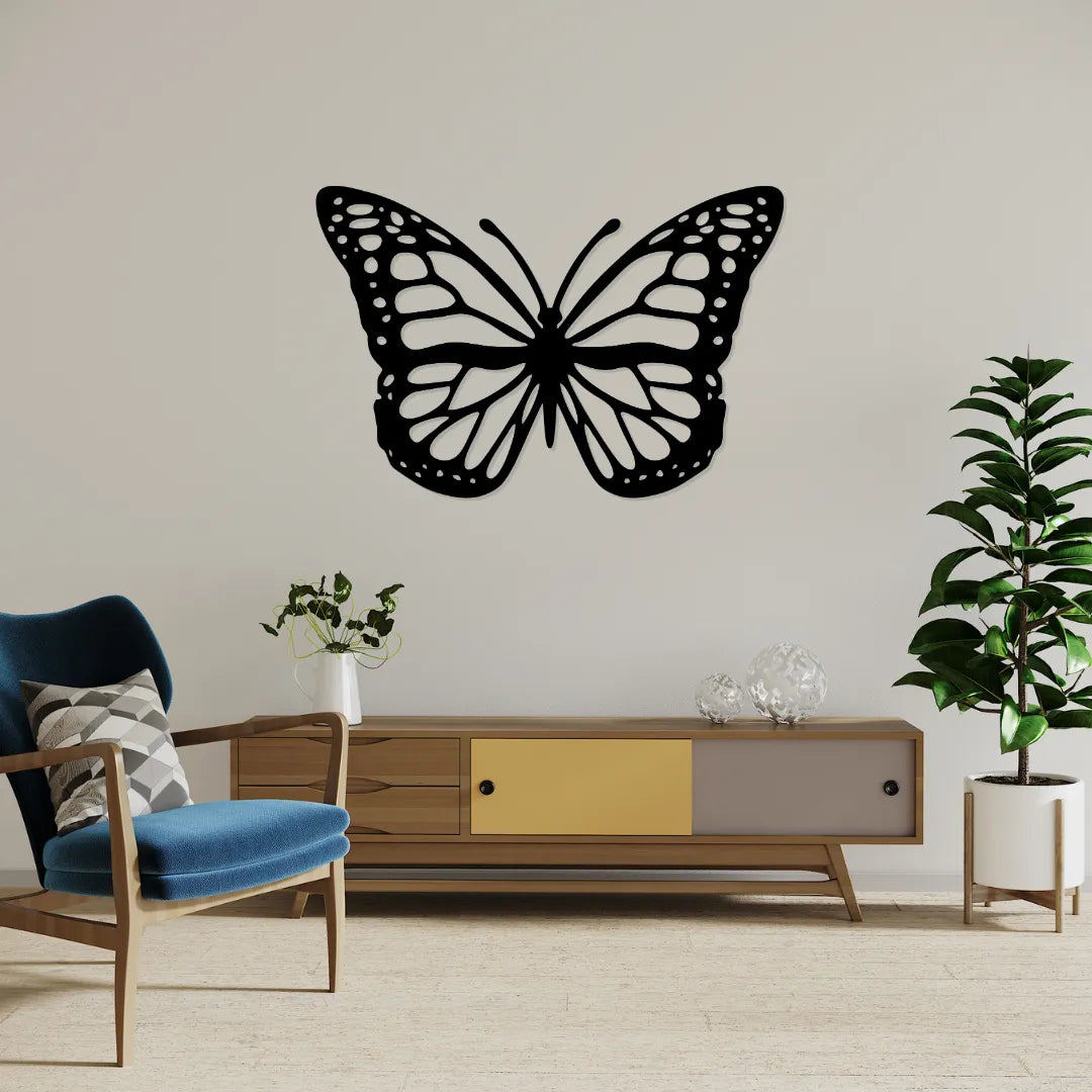 Black butterfly metal wall decor displayed above TV console with chair and plant