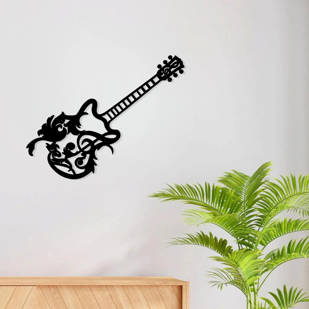 Black guitar silhouette metal wall art mounted on a light wall above a wooden cabinet