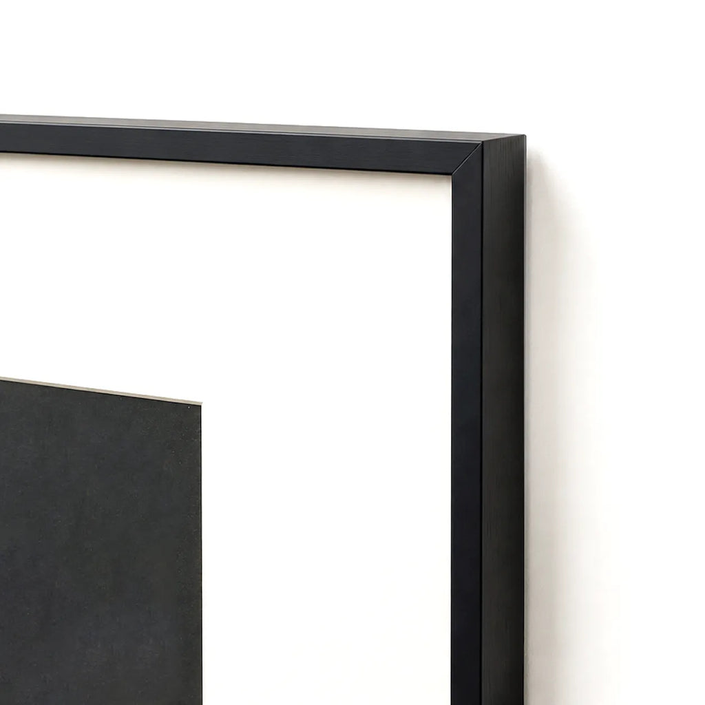 Close-up of black metal frame corner with cream matting border
