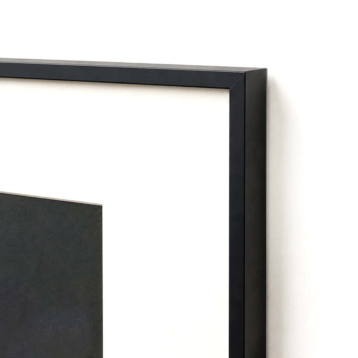 Close-up of black metal frame corner with cream matting border
