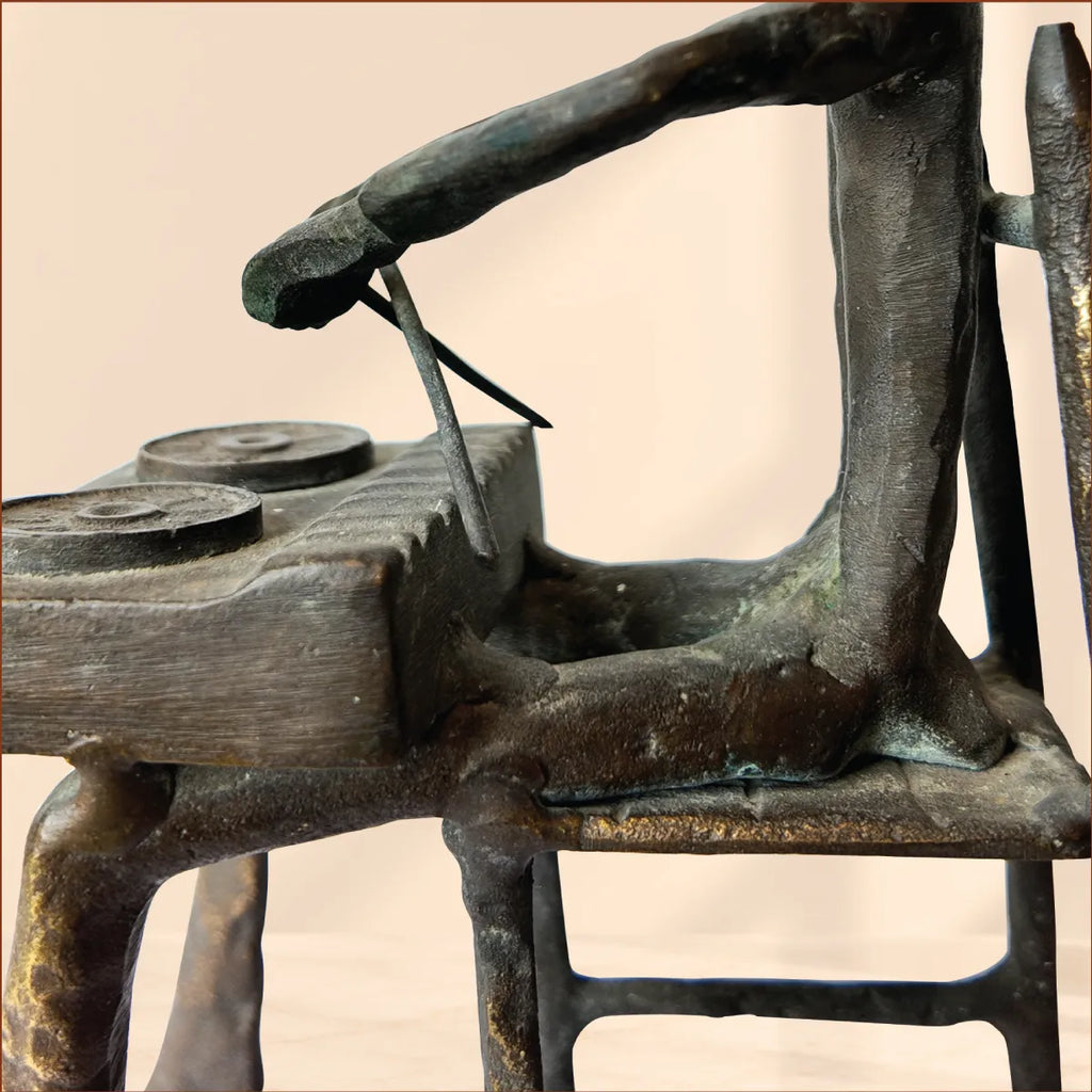 Detail of the brass drum table, drumsticks and chair frame on the antique brass figurine
