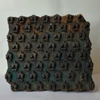 Front view of a square vintage Indian hand-carved wooden printing block showcasing rows of repeating three-pointed trefoil crown buds against a heavily distressed turquoise and teal green stained background patina