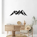 Mountain silhouette metal wall art above rustic console and chair
