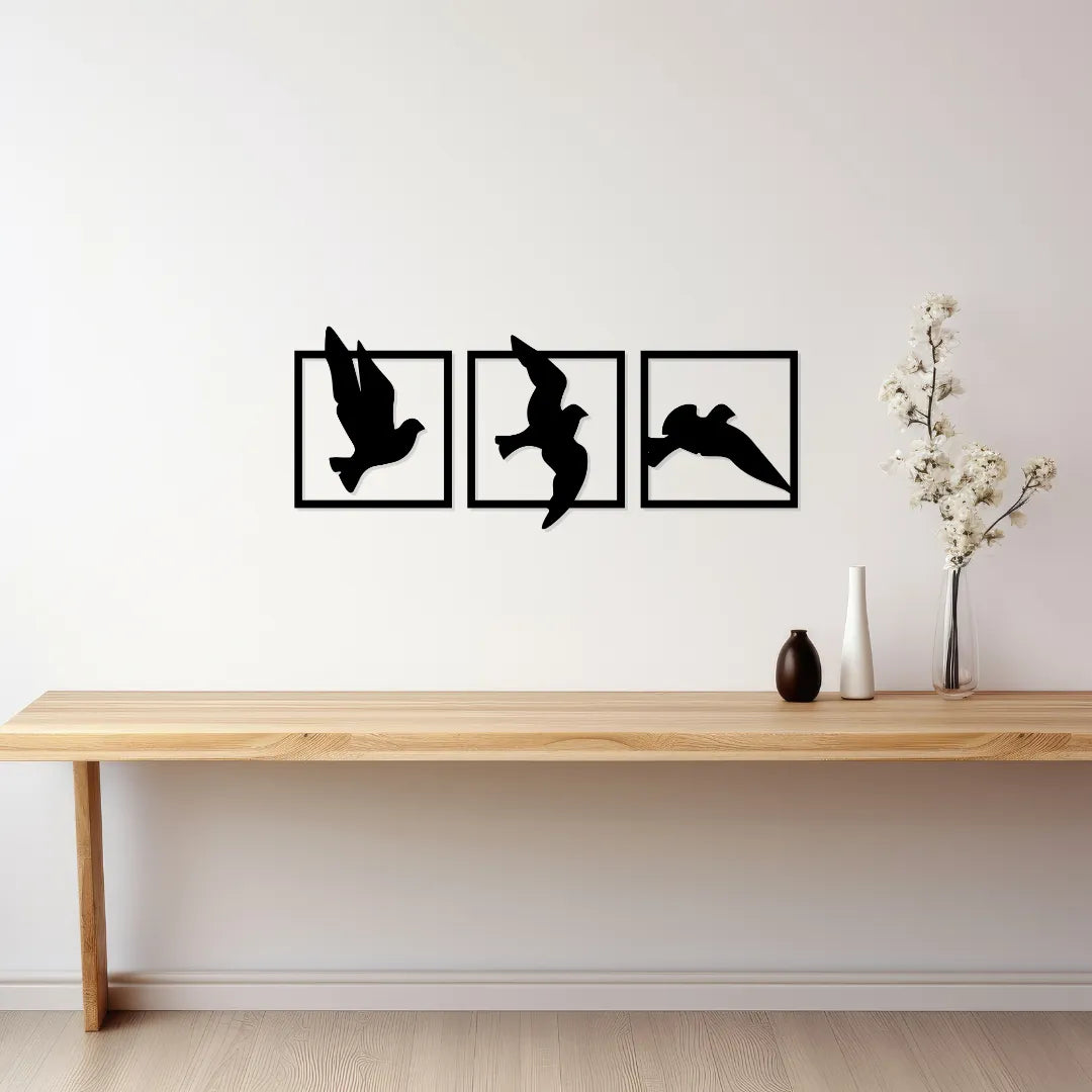 Three piece bird silhouette metal wall decor displayed above console table