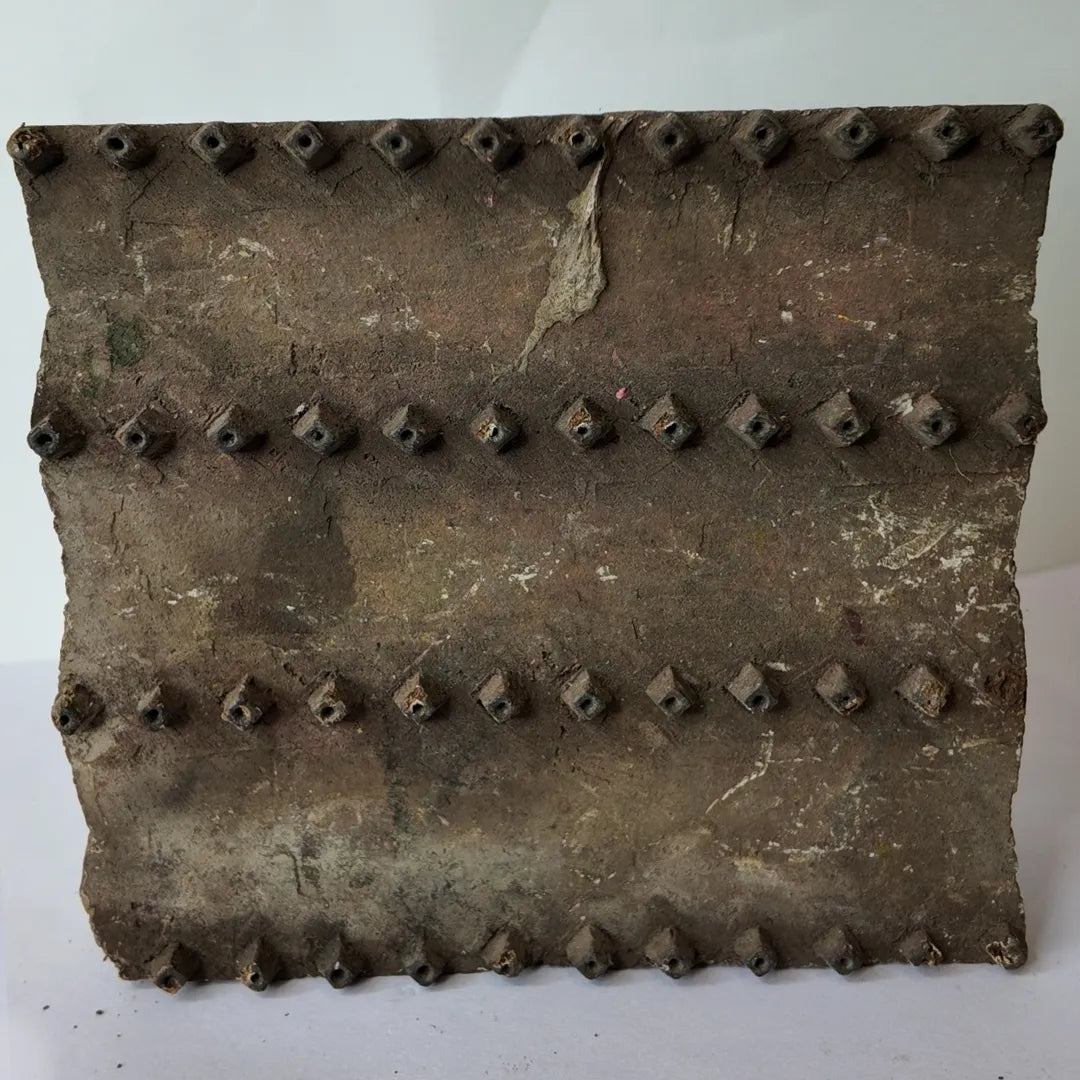 Vintage hand-carved wooden printing block with banded pyramid stud rows design
