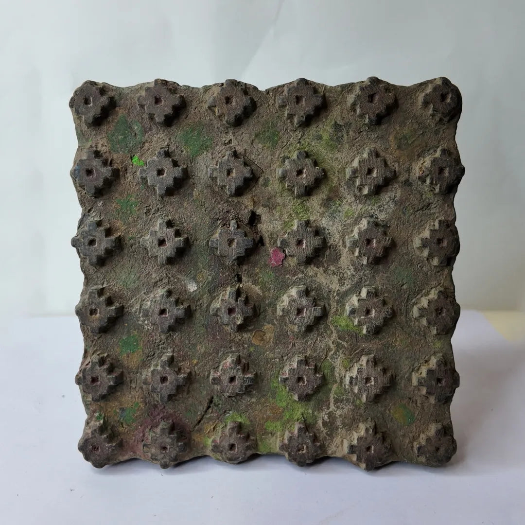 Vintage hand-carved wooden printing block with mossy fleur stud grid design

