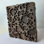 Vintage hand-carved wooden printing block with openwork floral vine panel design
