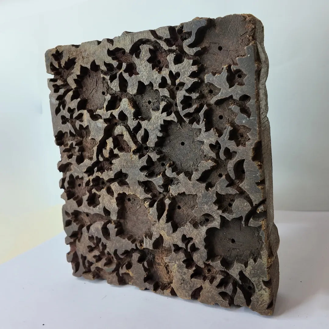 Vintage hand-carved wooden printing block with openwork floral vine panel design
