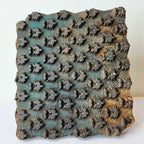 Vintage hand-carved wooden printing block with teal star bud grid design
