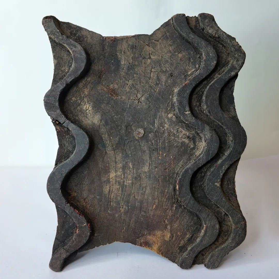 Vintage hand-carved wooden printing block with wavy ribbon groove design
