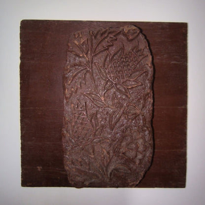 Rustic Indian wooden block with botanical carving of pinecone-like florals and leafy details mounted for wall décor