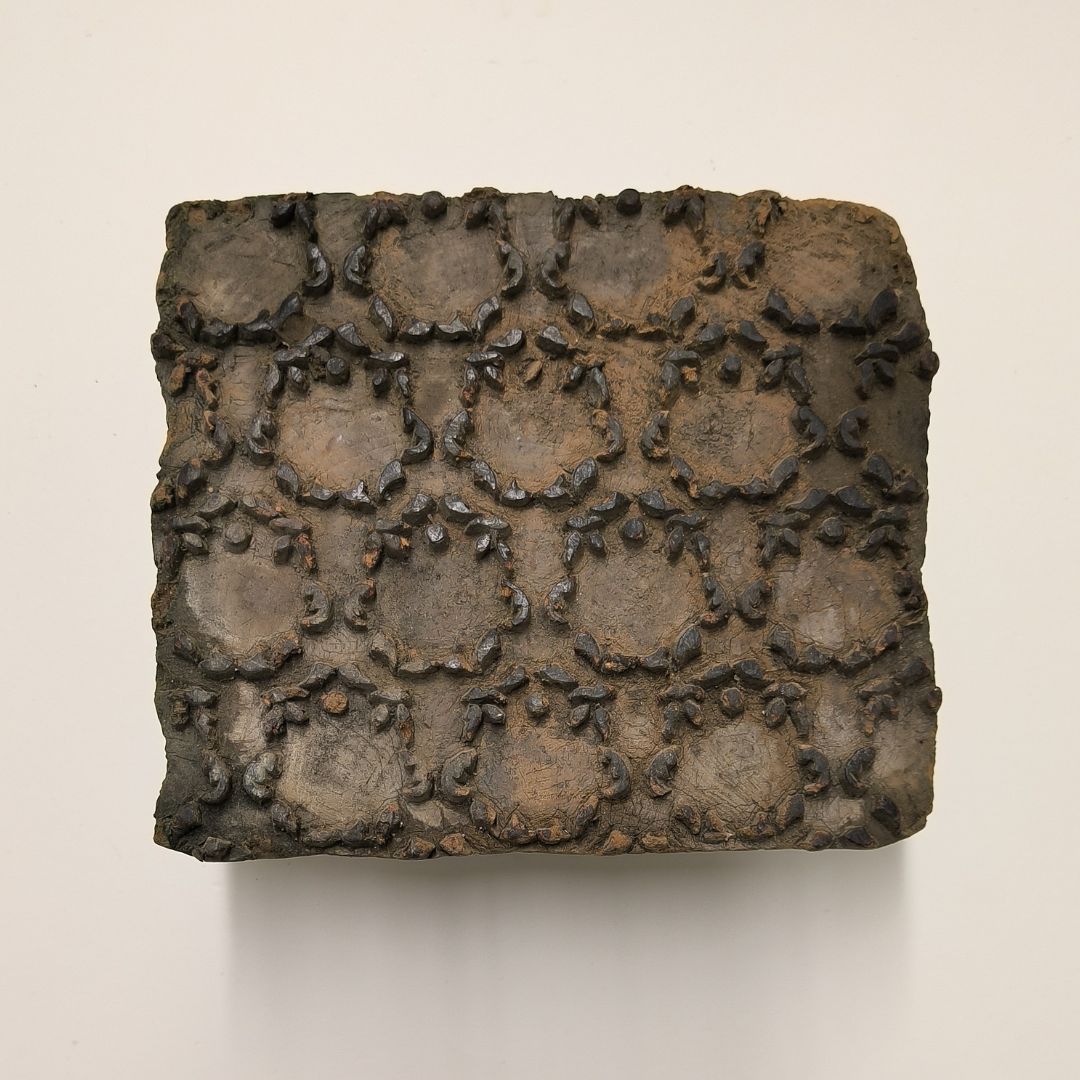 Vintage wooden stamp block with ornate circular floral frame pattern