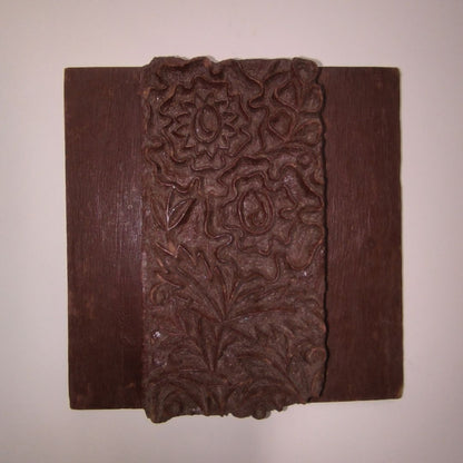 Vintage Indian wooden printing block featuring hand-carved floral and paisley-inspired motif on rustic wooden base