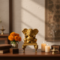 Brass Ganesha idol on stand with flowers and candles for pooja room décor