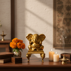 Brass Ganesha idol on stand with flowers and candles for pooja room décor