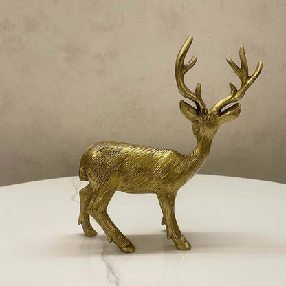 Side profile of a textured antique brass deer figurine displayed on a white marble surface