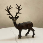 Handcrafted brass deer sculpture on white table