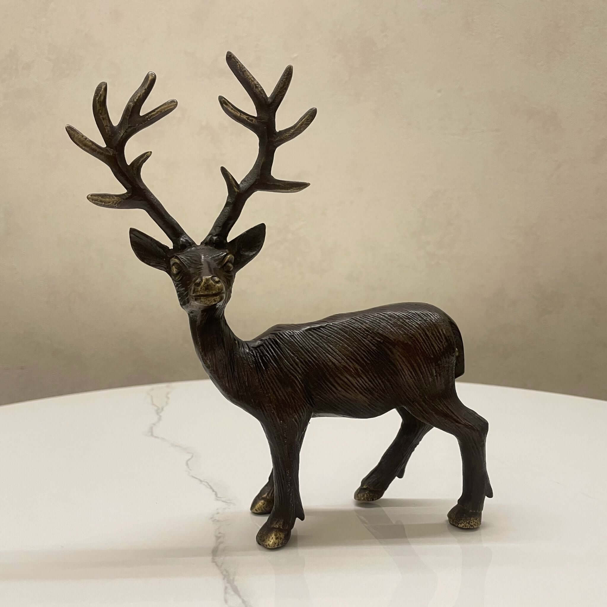 Handcrafted brass deer sculpture on white table