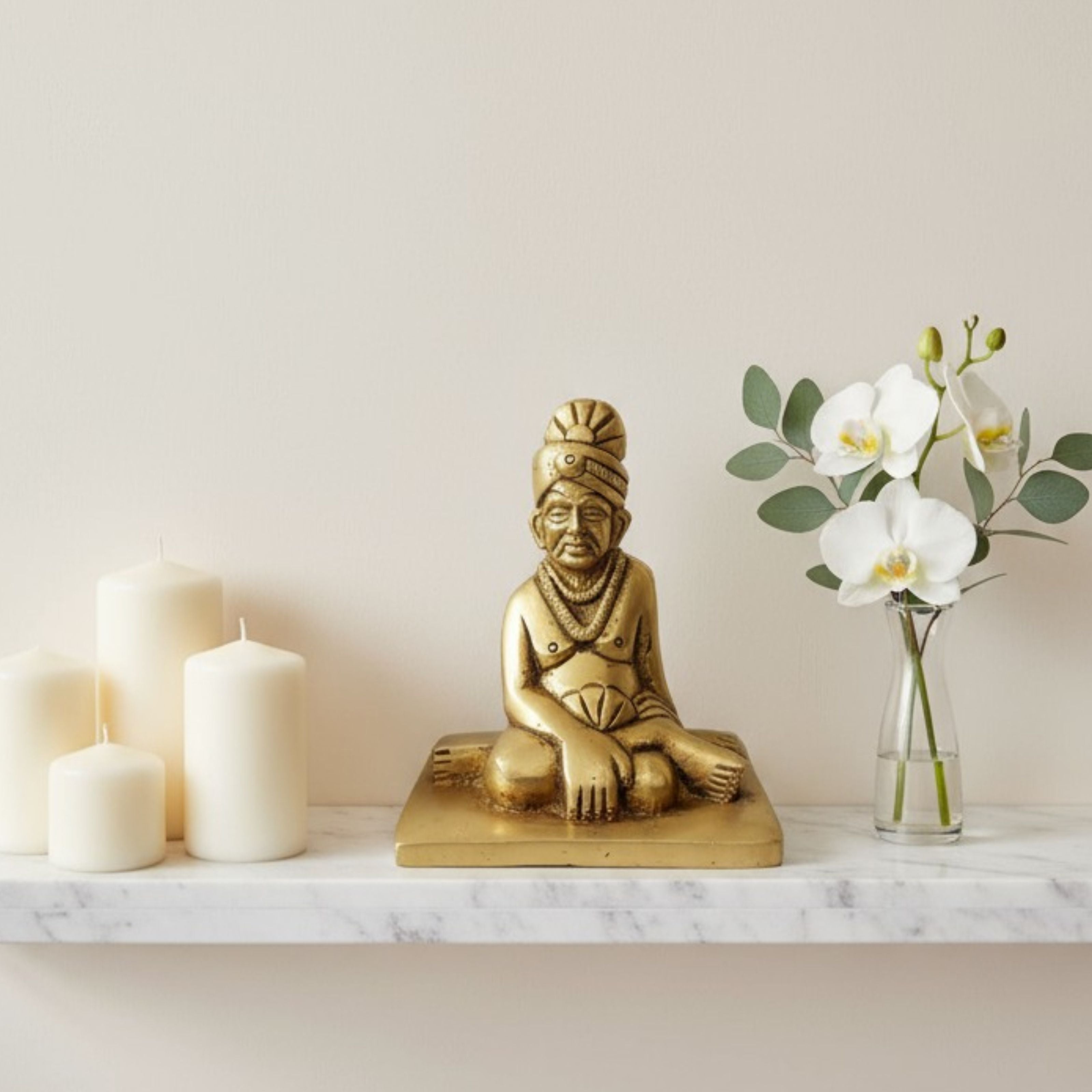 Swami Samarth Murti brass idol with candles and flowers in sacred corner