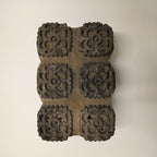 Hand-carved antique block with repeating floral bouquet patterns in rustic wood